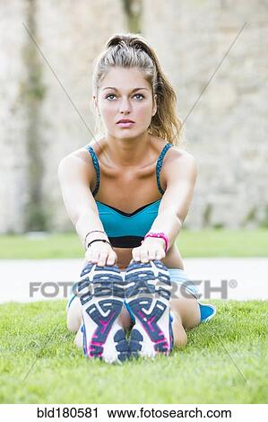 Stock Image - Caucasian woman stretching outdoors. Fotosearch