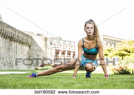 Stock Image - Caucasian woman stretching outdoors. Fotosearch
