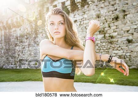 Stock Photo - Caucasian woman stretching outdoors. Fotosearch
