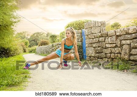 Stock Photo - Caucasian woman stretching outdoors. Fotosearch