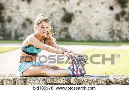 Stock Photograph - Caucasian woman stretching outdoors. Fotosearch