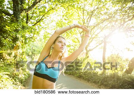 Stock Photograph - Caucasian woman stretching outdoors. Fotosearch