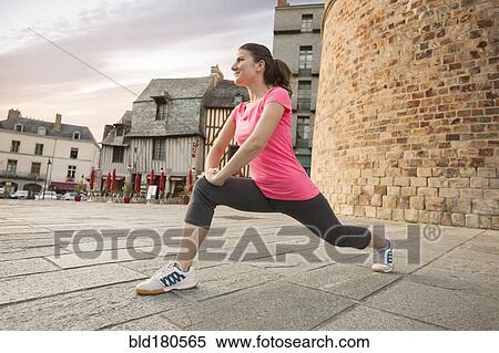 Stock Photography - Caucasian woman stretching outdoors. Fotosearch