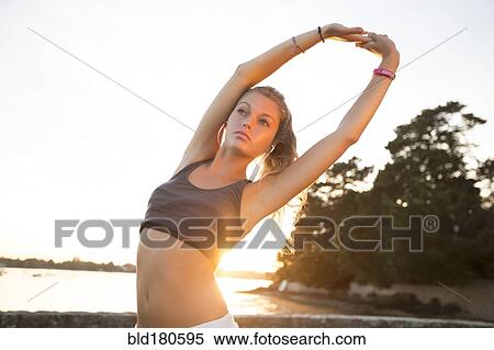 Stock Photography - Caucasian woman stretching outdoors. Fotosearch