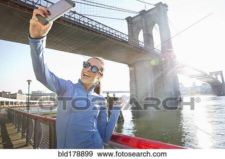 "Caucasian woman taking selfie on waterfront, New York, New York, United States" View Large Photo Image Stock Photo - "Caucasian woman taking selfie on waterfront, New York, New York, United States". Fotosearch