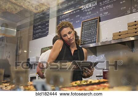 Caucasian woman talking on cell phone in cafe View Large Photo Image Picture - Caucasian woman talking on cell phone in cafe. Fotosearch