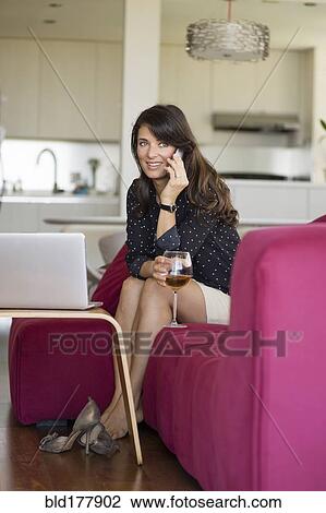 Caucasian woman talking on cell phone on sofa View Large Photo Image Stock Image - Caucasian woman talking on cell phone on sofa. Fotosearch