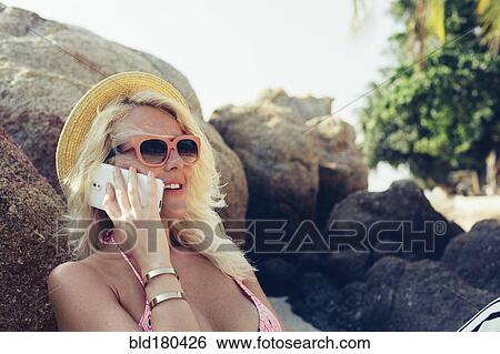 Stock Photograph - Caucasian woman talking on cell phone outdoors. Fotosearch