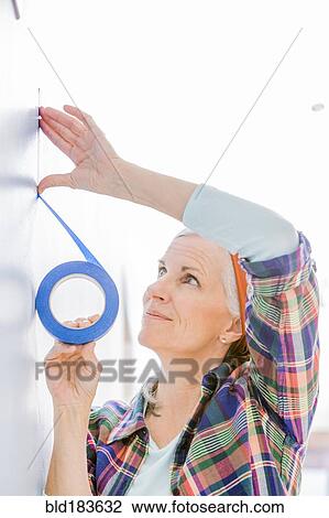 Caucasian woman taping off painting area View Large Photo Image Stock Image - Caucasian woman taping off painting area. Fotosearch