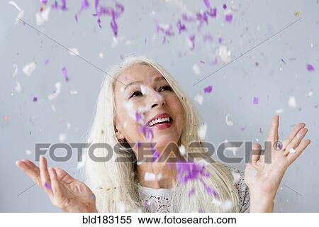 Stock Photography - Caucasian woman throwing confetti. Fotosearch