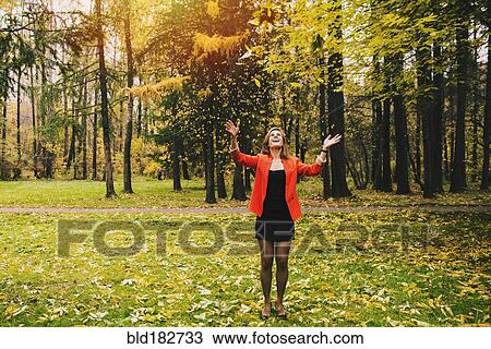 Caucasian woman tossing autumn leaves in park View Large Photo Image Stock Image - Caucasian woman tossing autumn leaves in park. Fotosearch