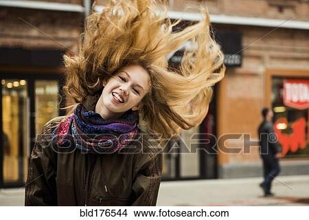 Picture - Caucasian woman tossing hair outdoors. Fotosearch
