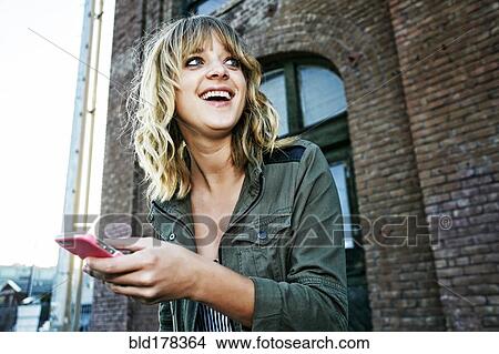 Caucasian woman using cell phone outdoors View Large Photo Image Picture - Caucasian woman using cell phone outdoors. Fotosearch