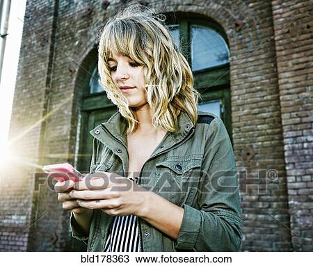 Caucasian woman using cell phone outdoors View Large Photo Image Stock Image - Caucasian woman using cell phone outdoors. Fotosearch