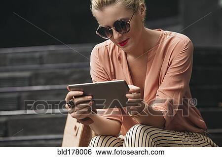 Caucasian woman using digital tablet on stairs View Large Photo Image Stock Photograph - Caucasian woman using digital tablet on stairs. Fotosearch