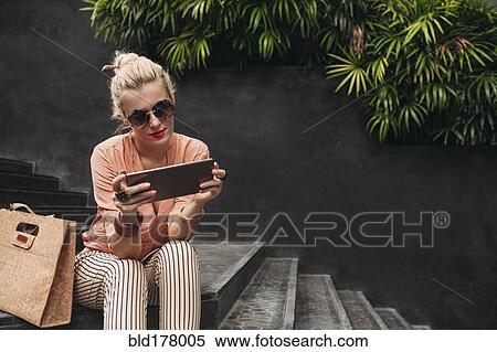 Caucasian woman using digital tablet on stairs View Large Photo Image Stock Photography - Caucasian woman using digital tablet on stairs. Fotosearch