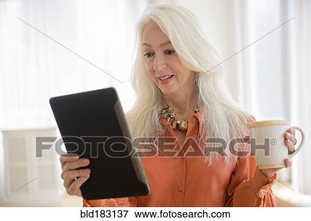 Caucasian woman using digital tablet View Large Photo Image Stock Photo - Caucasian woman using digital tablet. Fotosearch