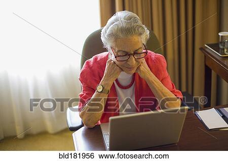 Caucasian woman using laptop at desk View Large Photo Image Stock Photograph - Caucasian woman using laptop at desk. Fotosearch
