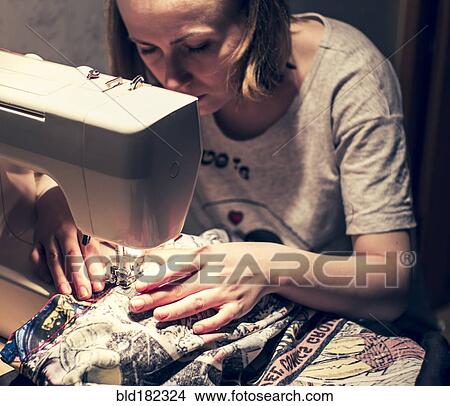 Picture - Caucasian woman using sewing machine. Fotosearch