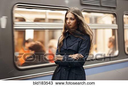 Stock Image - Caucasian woman waiting for subway train. Fotosearch