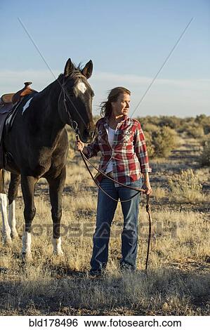 Caucasian woman walking horse in field View Large Photo Image Stock Photograph - Caucasian woman walking horse in field. Fotosearch