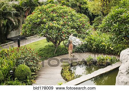 Stock Photo - Caucasian woman walking in garden. Fotosearch