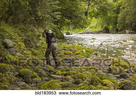 Stock Image - Caucasian woman walking in remote river. Fotosearch
