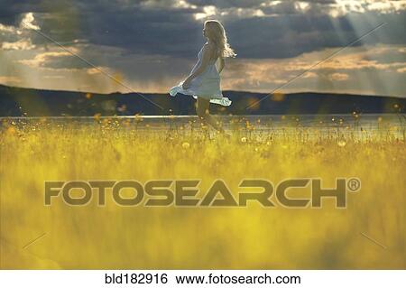 Stock Photograph - Caucasian woman walking in rural field. Fotosearch