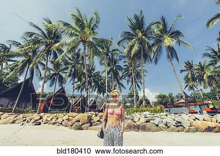 Stock Image - Caucasian woman walking on beach. Fotosearch