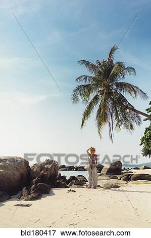 Stock Photo - Caucasian woman walking on beach. Fotosearch