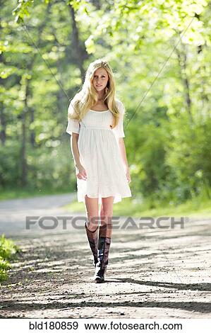 Caucasian woman walking on dirt path View Large Photo Image Stock Photo - Caucasian woman walking on dirt path. Fotosearch