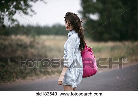 Caucasian woman walking on rural road View Large Photo Image Stock Image - Caucasian woman walking on rural road. Fotosearch