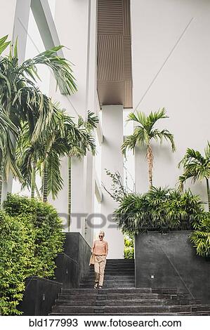Stock Image - Caucasian woman walking on stairs. Fotosearch