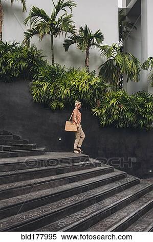 Stock Photography - Caucasian woman walking on stairs. Fotosearch