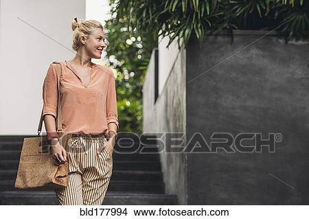 Picture - Caucasian woman walking outdoors. Fotosearch