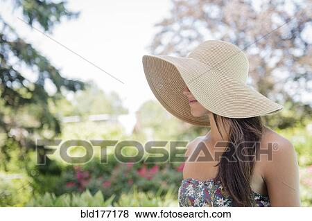 Stock Photo - Caucasian woman wearing sun hat outdoors. Fotosearch