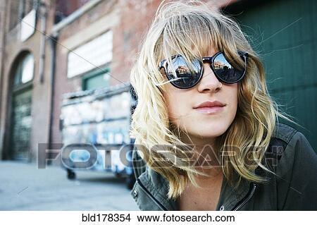 Picture - Caucasian woman wearing sunglasses outdoors. Fotosearch