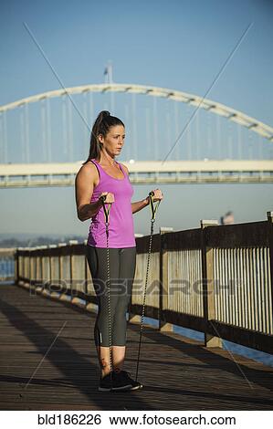 Caucasian woman working out on urban bridge View Large Photo Image Stock Photograph - Caucasian woman working out on urban bridge. Fotosearch