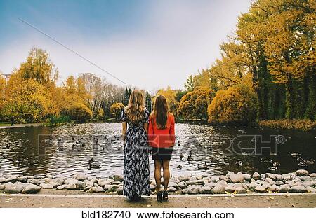 Caucasian women admiring pond in park View Large Photo Image Stock Image - Caucasian women admiring pond in park. Fotosearch