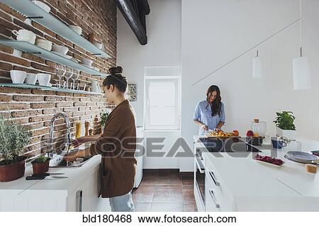 Stock Photo - Caucasian women cooking in kitchen. Fotosearch