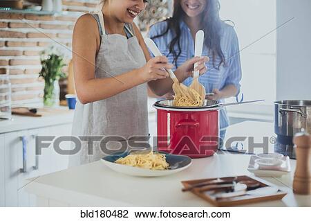 Caucasian women cooking pasta in kitchen View Large Photo Image Stock Image - Caucasian women cooking pasta in kitchen. Fotosearch