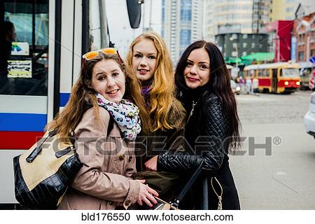 Stock Image - Caucasian women hugging outdoors. Fotosearch