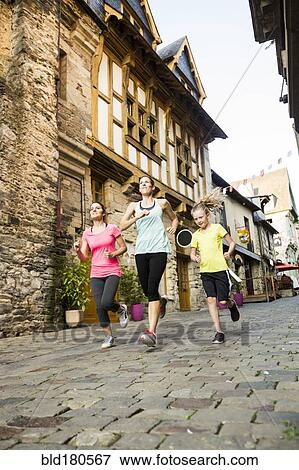 Stock Photo - Caucasian women jogging in village. Fotosearch
