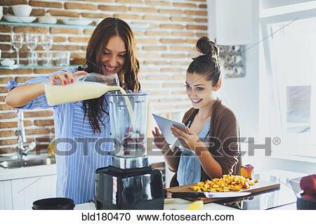 Caucasian women making smoothie in kitchen View Large Photo Image Stock Image - Caucasian women making smoothie in kitchen. Fotosearch