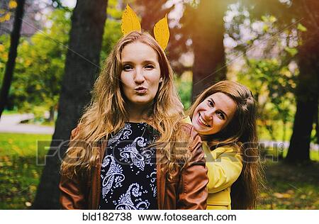 Caucasian women playing with autumn leaves View Large Photo Image Stock Photo - Caucasian women playing with autumn leaves. Fotosearch