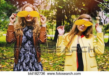 Caucasian women playing with autumn leaves View Large Photo Image Stock Photograph - Caucasian women playing with autumn leaves. Fotosearch