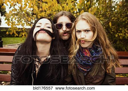 Caucasian women posing on bench View Large Photo Image Stock Photo - Caucasian women posing on bench. Fotosearch