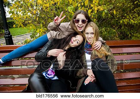 Caucasian women posing on bench View Large Photo Image Stock Photograph - Caucasian women posing on bench. Fotosearch