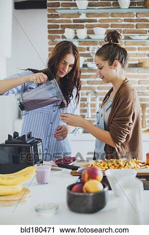 Caucasian women pouring smoothie in kitchen View Large Photo Image Stock Image - Caucasian women pouring smoothie in kitchen. Fotosearch