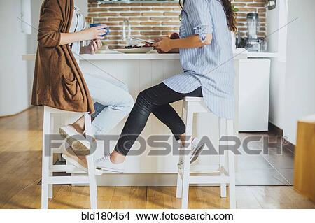 Picture - Caucasian women sitting at counter. Fotosearch